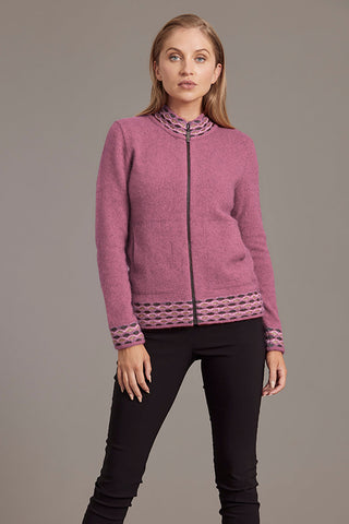 A woman is wearing a pink zip-up cardigan with wave pattern trim, paired with black pants.