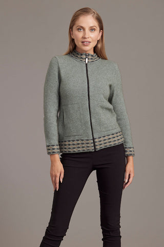 A woman is wearing a green zip-up cardigan with wave pattern trim, paired with black pants.