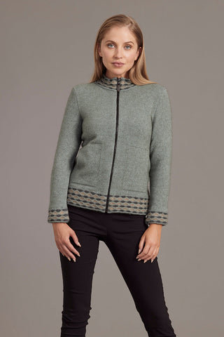 A woman is wearing a green zip-up cardigan with wave pattern trim, paired with black pants.