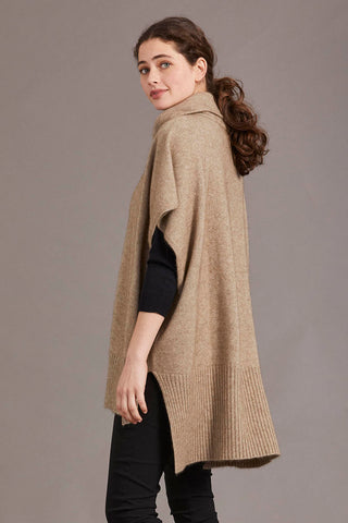 A model wearing a mocha poncho with a cowl neck and a step level hem, standing against a neutral background.