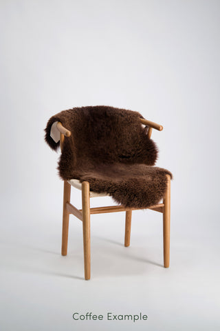 Ecowool Natural Undyed Sheepskin Rugs – Single. Chair with a brown fur cover on a white background