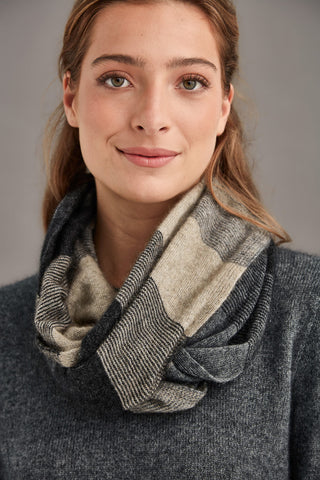 Woman wearing a sepia patterned snood scarf against a neutral background