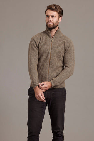 Man wearing a bark brown zip-up sweater against a gray background