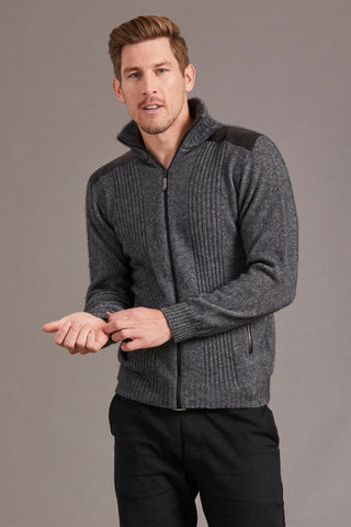 Man wearing a gray sweater with lambskin leather accents against a plain background