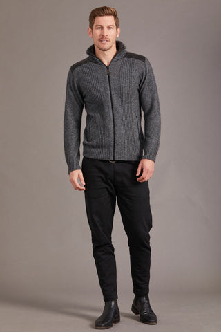 Man wearing a gray sweater with lambskin leather accents against a plain background