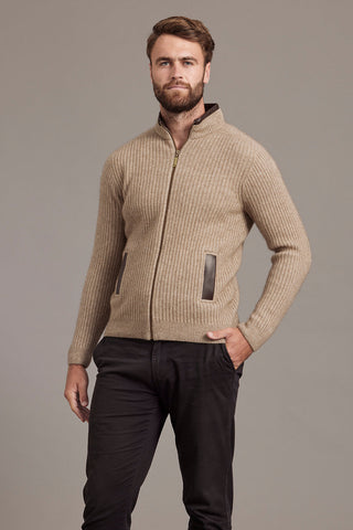 Man wearing a mocha brown knitted jacket against a plain background