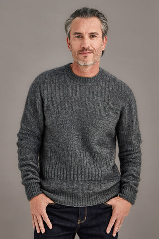 Man wearing a pewter gray detailed sweater against a plain background