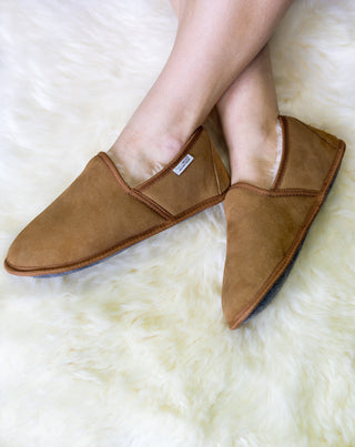 Pair of brown sheepskin slippers on foot
