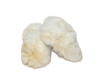 Pair of white sheepskin baby booties on a white background