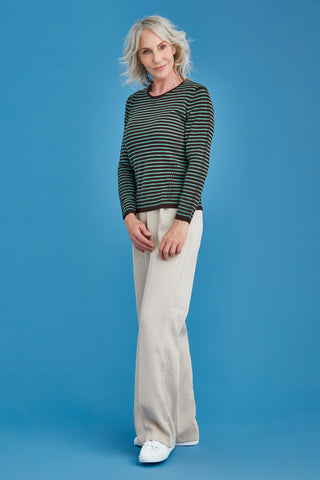 Woman wearing a green and brown striped sweater against a blue background