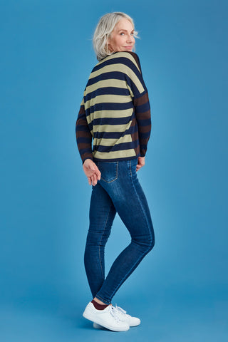 Woman wearing a striped sweater and jeans on a blue background
