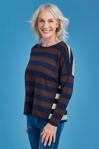 Woman wearing a striped sweater against a blue background