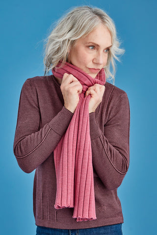 Woman wearing a pink scarf against a blue background