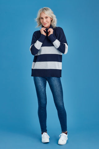 Woman wearing a navy and white striped merino sweater against a blue background