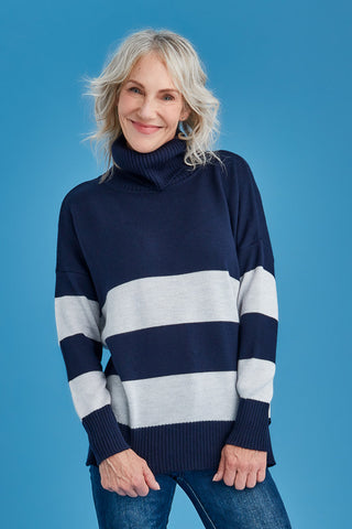 Woman wearing a navy and white striped merino sweater against a blue background