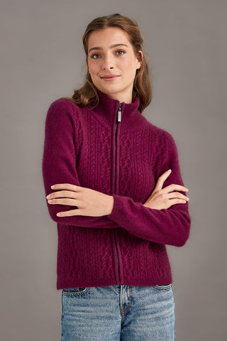 Woman wearing a berry sweater with a zipper on a gray background