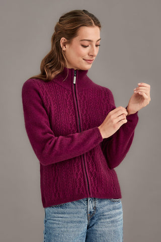 Woman wearing a berry sweater with a zipper on a gray background