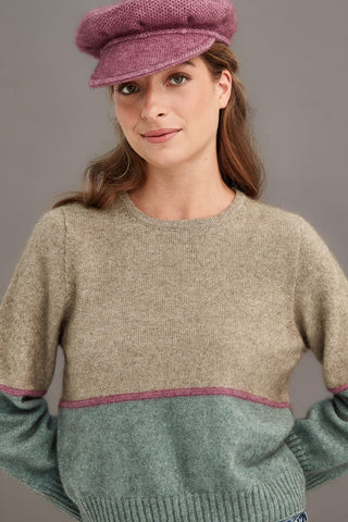 Woman wearing a pink knitted cap against a gray background