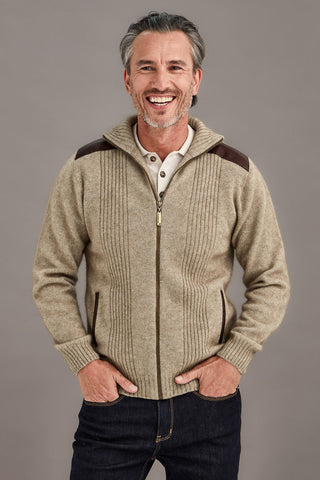 Man wearing a beige zip-up hoodie with brown accents on a gray background