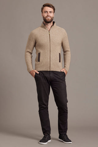 Man wearing a mocha brown knitted jacket against a plain background