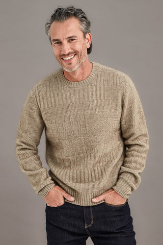 Man wearing a mocha brown detailed sweater against a plain background