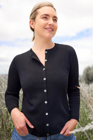 Women standing outdoors wearing a black button-down crew neck cardigan.