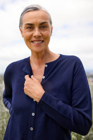 Women standing outdoors wearing a navy button-down crew neck cardigan.