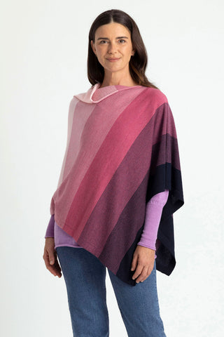 Woman wearing a pink and navy striped poncho against a white background