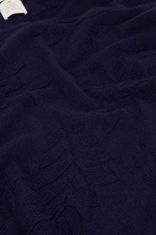 Detail of navy sweater with floral patterns